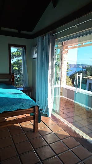 Een slaapkamer met een bed, een raam en een balkon met uitzicht.