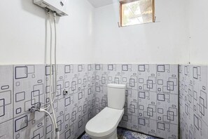 A small bathroom with a toilet, a shower, and a window. - Cozzy Villa Tb (BANDUNG)