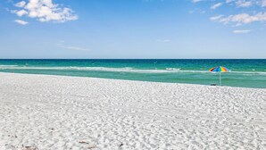 En strand med vit sand och en klarblå himmel.
