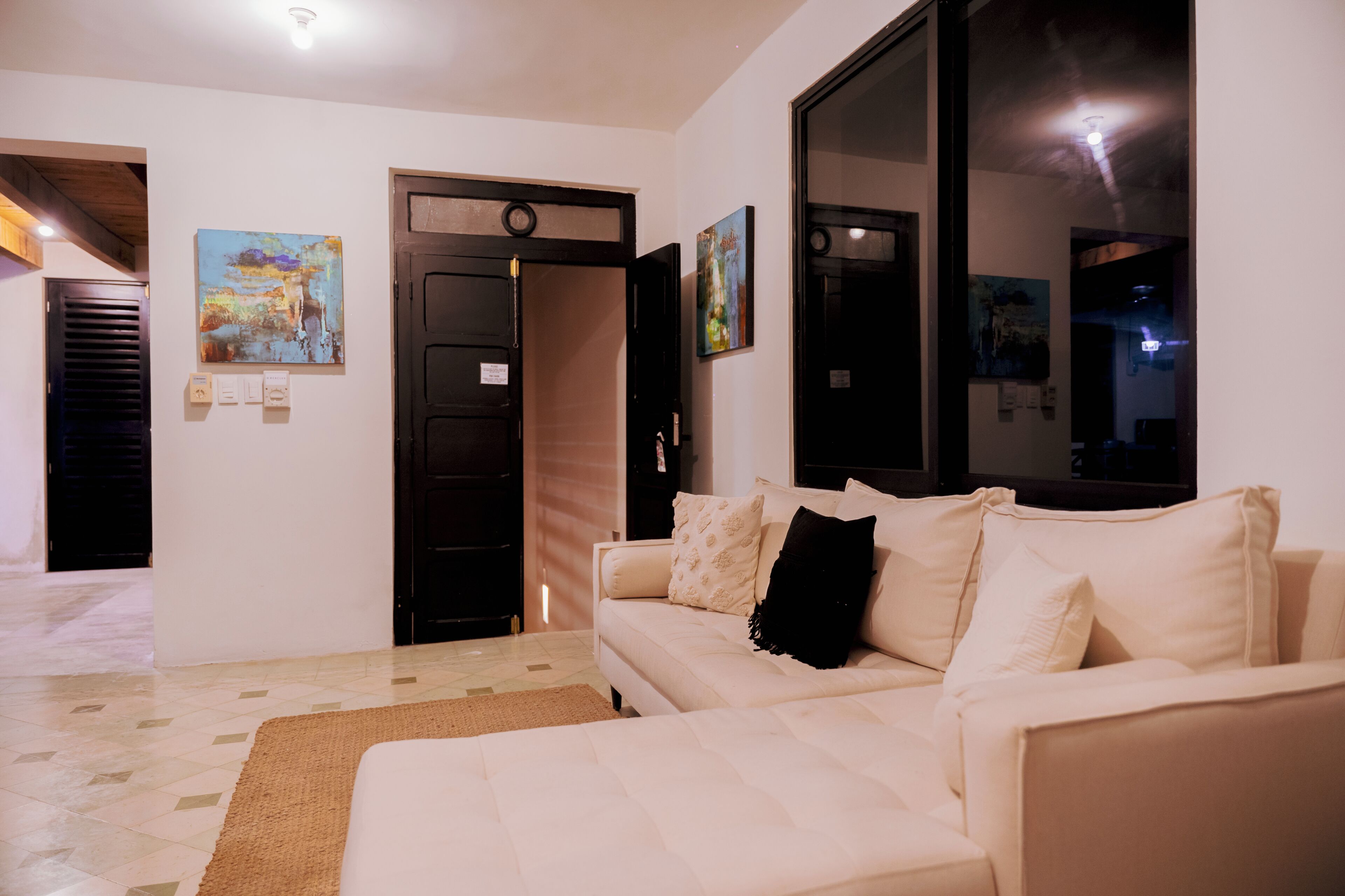 A living room with a sofa, a rug, and artwork on the walls.