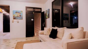 A living room with a sofa, a rug, and artwork on the walls.