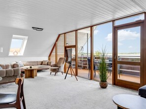 Ein geräumiges Loft mit einer großen Schiebeglasdoor, die zu einer Außenterrasse führt.