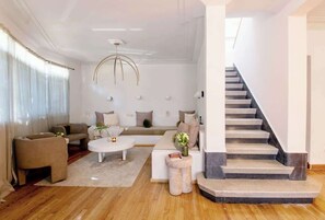 Ein modernes Wohnzimmer mit einer Couch, einem Couchtisch und einer Treppe.