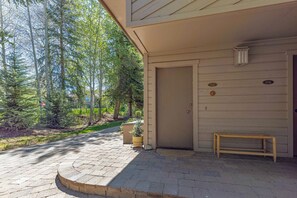 A paved driveway leading to a building with a door marked '1537' and a bench outside. - Alpine Loft | Walk to Ski | Hot Tub | Pool | Deck (Sun Valley)