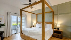 A bedroom with a four-poster bed, a ceiling fan, and a view through a glass door. - Centre Court Pacifica Near Disney, Golf Course, WaterPark (Kissimmee)