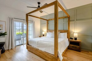 A bedroom with a four-poster bed, a ceiling fan, and a view through a glass door. - Centre Court Pacifica Near Disney, Golf Course, WaterPark (Kissimmee)