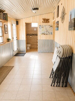 Ein Holzinnenraum mit einer Karte an der Wand, einem Badezimmer und einem Küchenutensilienständer.