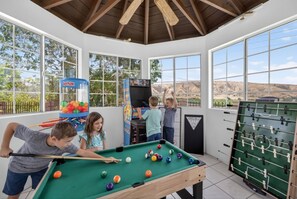 A recreational room with a pool table, foosball table, and a claw machine. - Executive Corporate Stay | 4BR/4BA Pool-Spa & Golf (Redlands)