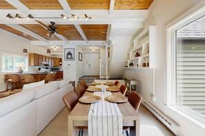 Un comedor amplio con una larga mesa de madera, múltiples sillas y un ventilador de techo.