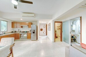 A modern kitchen with wooden cabinets, a refrigerator, and a stove. - Beautiful Condo with pool and close to the beach, centrally located in the North Hotel Zone. (Puerto Vallarta)