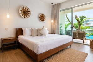 Ein modernes Hotelzimmer mit einem großen Bett, einem Nachttisch, einer Wandlampe und Blick auf einen Pool und Grünflächen.
