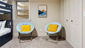 A room with bunk beds, two armchairs with yellow cushions, a window, and a wall-mounted artwork. - ✨ Lake Compound | Sauna-Hot Tub-Steam Shower-Cold Plunge (Interlochen)