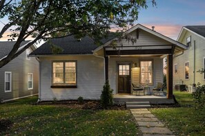 A two-story house with a porch, a small front yard, and a tree. - Speakeasy. East Nash. Hot tub. Mins to Broadway (Nashville)