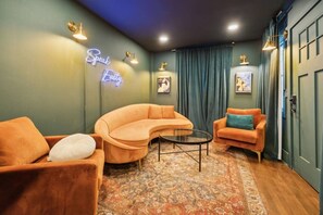 A cozy room with a curved sofa, a small round table, and a patterned rug. - Speakeasy. East Nash. Hot tub. Mins to Broadway (Nashville)