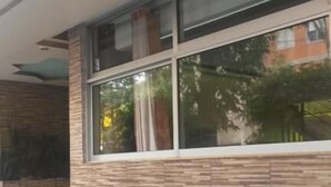 Un edificio con fachada moderna, ventanas grandes y una escalera visible que lleva a la entrada.