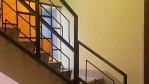 Una escalera con barandales negros y una pared con un diseño geométrico.