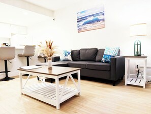 Ein modernes Wohnzimmer mit einer Couch, einem Couchtisch und einer Lampe.