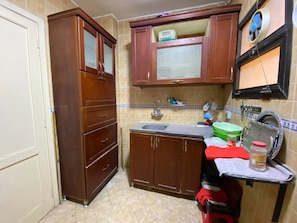 A compact kitchen with wooden cabinets, a sink, and a small countertop. - Luxury Apartment in Rehab City (Cairo Governorate)