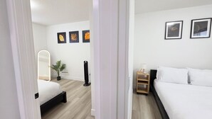 A modern bedroom with a bed, bedside table, lamp, and wall art. - New 2-Bed Suite in SW Edmonton near Windermere & YEG Airport (Edmonton)