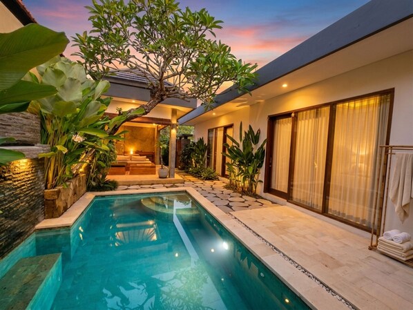 Ein modernes Haus mit Swimmingpool, gemütlicher Einrichtung und üppigem Grün.