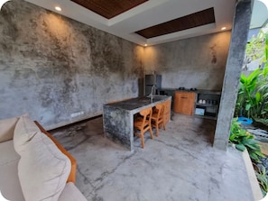 Eine moderne Küche mit einer zentralen Kochinsel, Holzkstühlen und einem eingebauten Backofen.