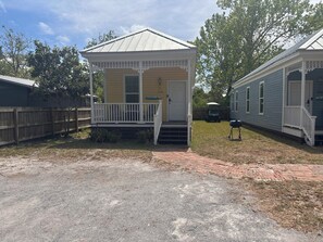 A small, single-story house with a porch, a front door, and a small front yard. - Cozy 2-bedroom house in pleasant Apalachicola with AC (Apalachicola)