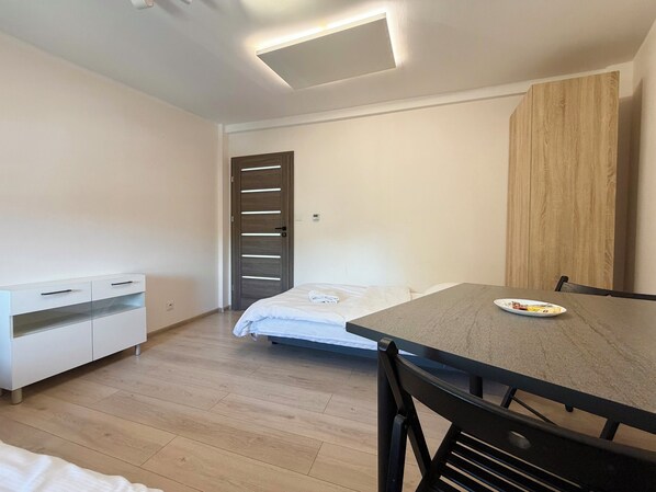 Une chambre à coucher avec un lit, un bureau, une chaise, une armoire et une porte.