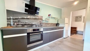 A modern kitchen with a built-in oven, a coffee maker, and a refrigerator. - Park Leśnicki Homely Studio #3 (Wrocław)