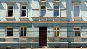 A multi-story building with a symmetrical facade, evenly spaced windows, and a central entrance with a door. - Park Leśnicki Homely Studio #3 (Wrocław)