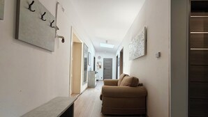 A hallway with a bench, a sofa, and a map on the wall. - Park Leśnicki Homely Studio #3 (Wrocław)