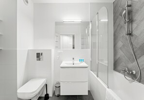 A modern bathroom with a toilet, sink, and shower. - Górka Narodowa Chic Apartment (Kraków)