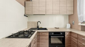 Uma cozinha moderna com fogão a gás, forno e pia.