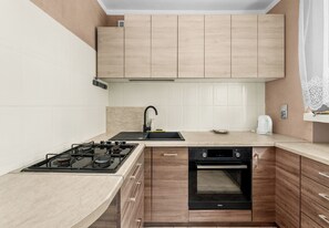 Eine moderne Küche mit Gasherd, Backofen und Spüle.