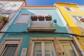 Ein Gebäude mit Balkon, einem Fenster mit Rollläden und einem Schild mit der Nummer 16 114.