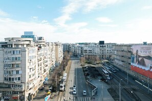 Um edifício de vários andares com um pátio central, uma linha de bonde e um grande outdoor.