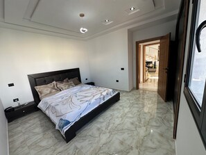 Ein Schlafzimmer mit einem Bett, einem Nachttisch, einem Einbauschrank und einer Deckenleuchte.