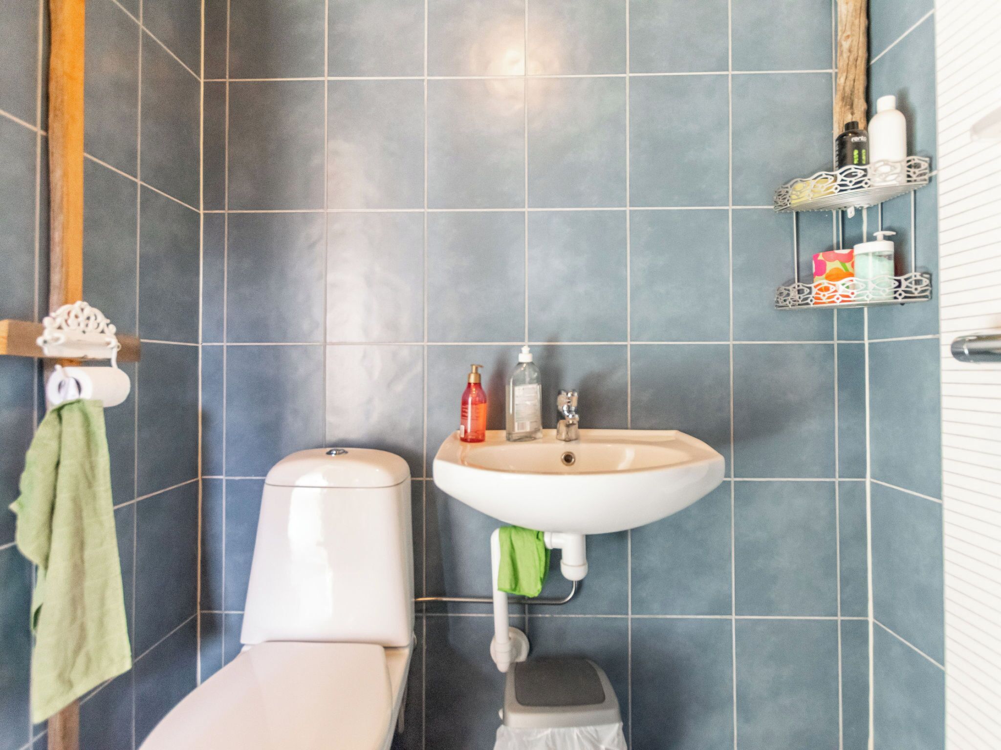Un baño con inodoro, lavamanos y paredes de azulejos.