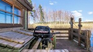 Un molo di legno conduce a una cabina con un motore fuoribordo Mercury sul molo.