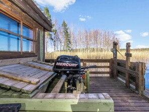 Puinen laituri johtaa mökille, ja laiturilla on kiinnitettynä Mercury-merkkinen perämoottori.