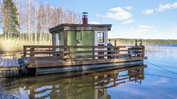 Une jetée en bois avec une petite cabane, une canne à pêche et un lac paisible.
