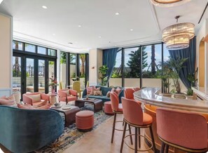 A spacious lounge area with comfortable seating, large windows, and a view of the outdoors. - New Studio in Wynwood (Miami)