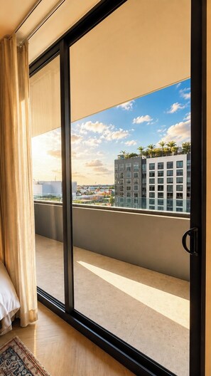 A modern room with a large sliding glass door leading to a balcony with a city view. - New Studio in Wynwood (Miami)
