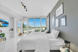 A modern hotel room with a large bed, a TV, and a balcony with a city view. - 48th floor studio ★ Icon Brickell ★ (Miami)