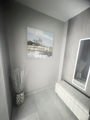 A minimalist room with a large window, a bench, and a painting on the wall. - From the City to the Country. Close to beaches, restaurants, malls and more. (San Antonio)