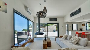A modern living room with a sofa, a wooden coffee table, and a hanging light fixture. - Caray - By Almarina Villas (BENISSA)
