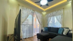 A modern living room with a flat-screen TV, a ceiling fan, a sofa, and a coffee table. - BethShalom Guest House by Jeff and Malou, 4 Bedrooms and 2 Bathrooms (Dasmarinas)