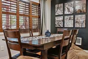 Un coin repas avec une table en bois, des chaises et un vase.