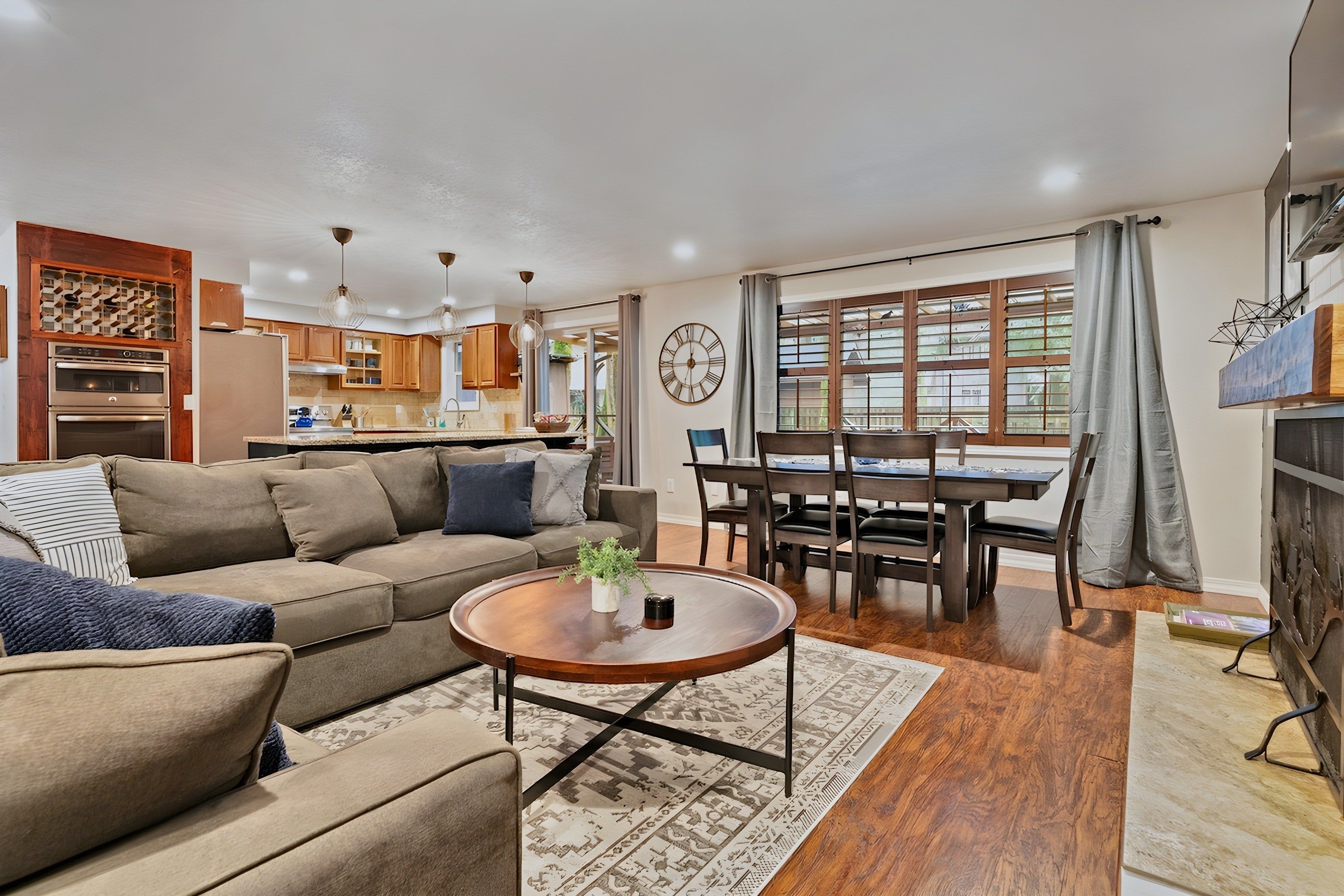 A modern living room with a sofa, coffee table, and dining area with chairs and a table.