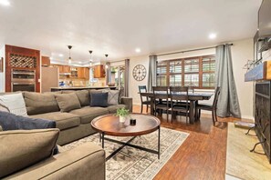 Ein Wohnzimmer mit Sofa, Couchtisch und Essbereich mit Tisch und Stühlen.