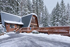 A cabin with a sloped roof, wooden deck, and a snow-covered landscape. - Family Winter Cabin • Game Room • Dogs OK (Rhododendron)